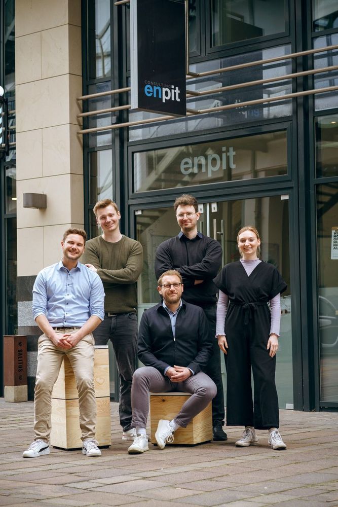 Kleine Teamgruppe der enpit GmbH & Co. KG vor dem Büro in Paderborn – spezialisiert auf agile Softwareentwicklung und UX Design.