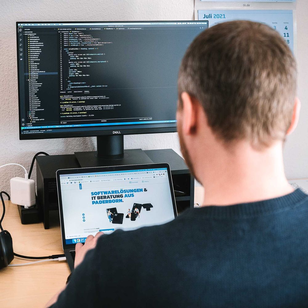 Entwickler arbeitet am Cloud-Move-Projekt mit Webtechnologien am Desktop und Laptop